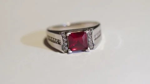 Silver ring with red square gemstone and clear stones Stock Photos