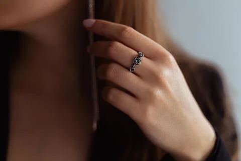 Silver rose ring on a middle finger of a young blonde lady Stock Photos