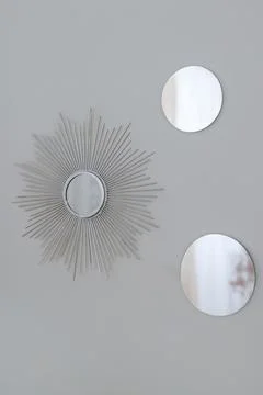 Silver round wall mirrors framed by Sun-Ray. Stock Photos