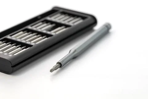 A silver screwdriver with interchangeable bits in a black case on a white Foto stock