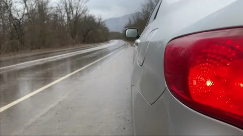 Silver sedan car standing on the side of the road on a rainy day Stock Footage 146254965