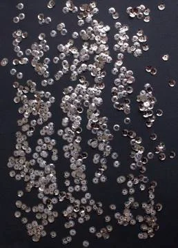 Silver sequins on black background Stock Photos