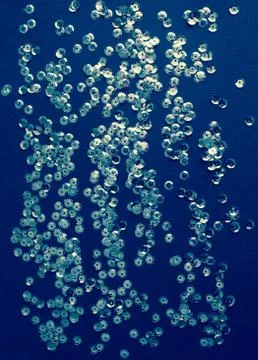 Silver sequins on blue background Stock Photos