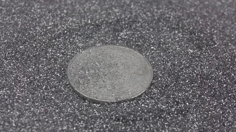 Silver sequins falling on cryptocurrency bitcoin. Real btc metal coin. Slow Stock Footage 155356518