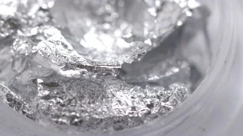 Silver sequins in a jar rotate in a circle Stock Footage 219483916