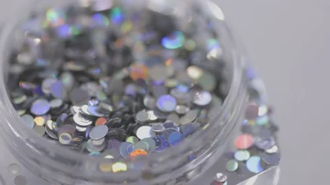 Silver sequins in a jar rotate in a circle Stock Footage 219483955