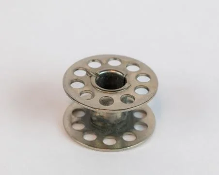 Silver sewing machine bobbin isolated white Stock Photos