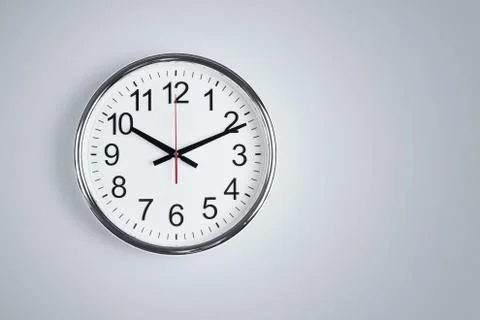 Silver shiny clock hanging at the wall with copy space Stock Photos