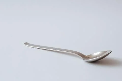 Silver shiny spoon on white background, kitchenware, copy space Foto stock