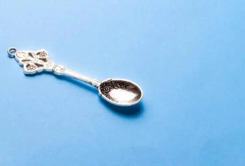 Silver small spoon on a blue background Stock Photos