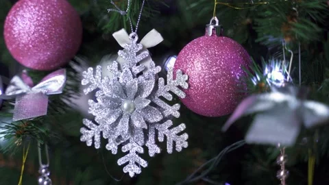 Silver snowflake and pink glitter balls, next to a flashing garland on a christm Stock Footage 165544742