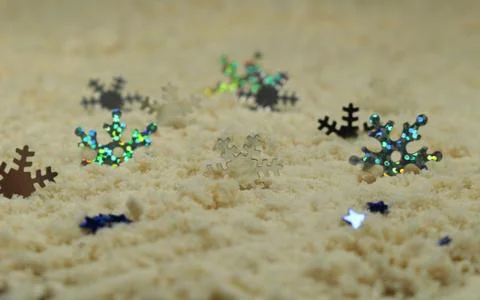 Silver snowflakes on white sand Stock Photos