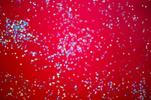 Silver sparkles on a bright red background. selective focus, blur Stock Photos