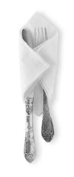 Silver spoon and fork wrapped in white napkin isolated Stock Photos