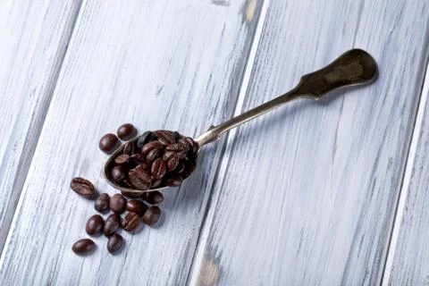 Silver spoon with coffee beans Stock Photos