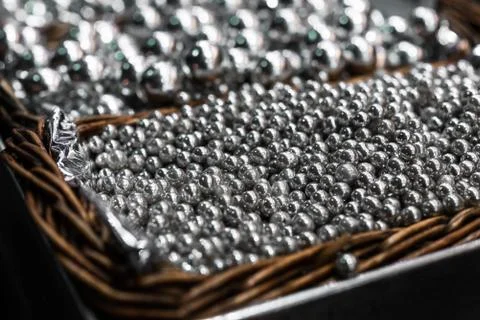 Silver sprinkle sugar candy for cake decoration in a wooden basket. Stock Photos
