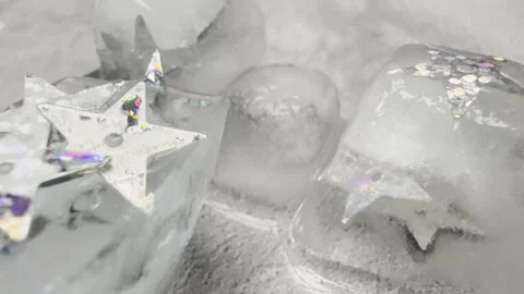 Silver Star Sequins on Melting Ice with Hand Touch Macro Video Stock Footage 333554687