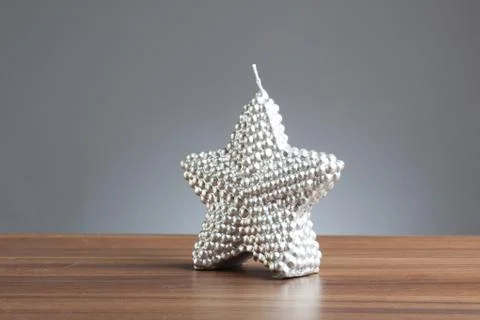 Silver star shape candle on table Stock Photos