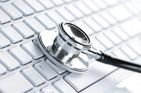 Silver stethoscope lying down on an laptop Stock Photos