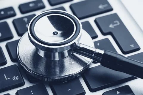 Silver stethoscope lying down on an notebook, blue toned 写真素材