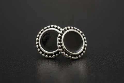 Silver stud earrings isolated on black Stock Photos