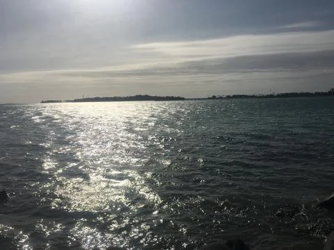Silver sun rays over calm sea Stock Photos