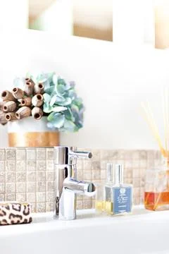 Silver tap with scent diffuser bottle in a modern bathroom Stock Photos