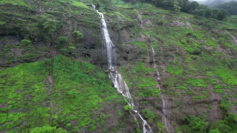 Silver Thread on a Green Canvas: The Majestic Cliff Waterfall. Stock Footage 342289576