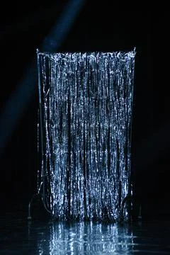 Silver Tinsel Curtain on Stage with Dramatic Spotlight Stock Photos
