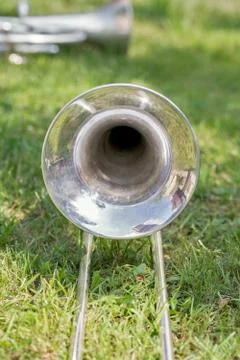 Silver trombone on th grass Stock Photos