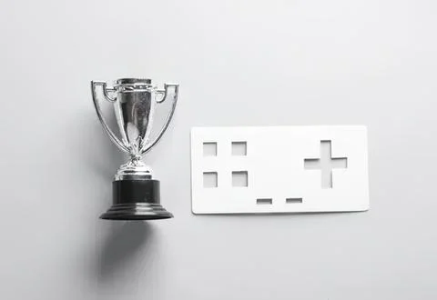 Silver trophy and game controller on white background Stock Photos
