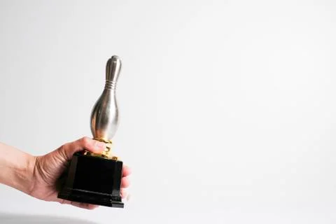 Silver trophy held by hand, isolated in white background. Stockfoto's