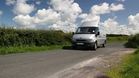 Silver Van drives through the countryside on a road in the summer. Blue sky Stock Footage 128376101