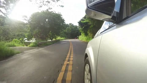 A Silver Van Driving Down An Empty Road Surrounded By Lush Green Trees  Stock Footage 83927582