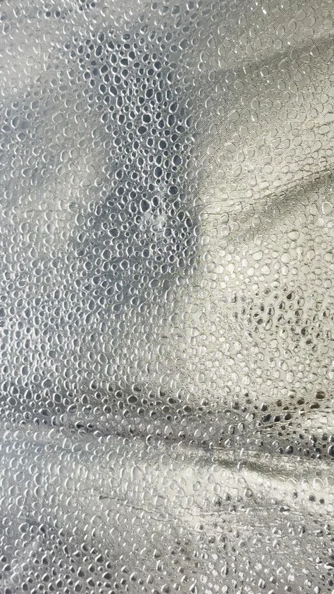 Silver water droplets condensing on metallic surface in shimmering macro video c Stock Footage 327637294