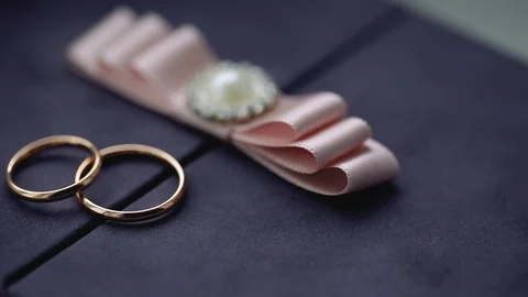Silver Wedding Rings on a box with a pink bow macro closeup shoot diamon Stock Footage 114496314