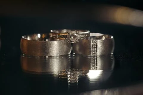 Silver wedding rings on table with reflection Stock Photos