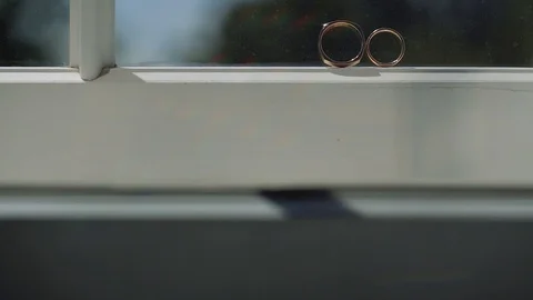 Silver Wedding Rings on the window with sunlights light flares macro closeup Vídeo Stock 114487525