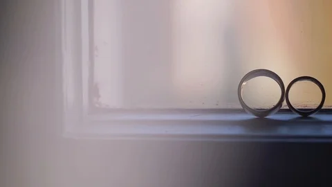 Silver Wedding Rings on the window with sunlights light flares macro closeup Stock Footage 114488572