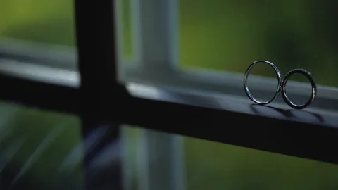 Silver Wedding Rings on the window with sunlights light flares macro closeup Stock Footage 114488853