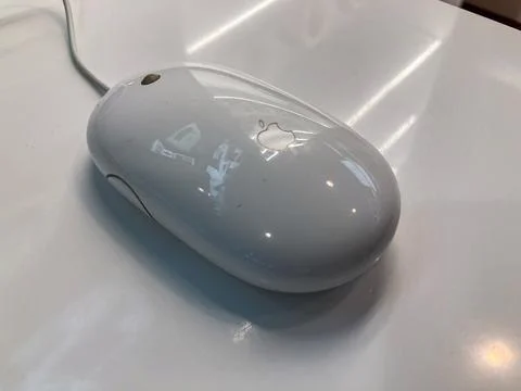Silver wireless Apple Magic Mouse on reflective, matte-finished surface in mo 写真素材
