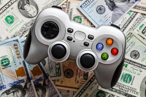 Silver wireless gamepad on dollar bills background Stock Photos