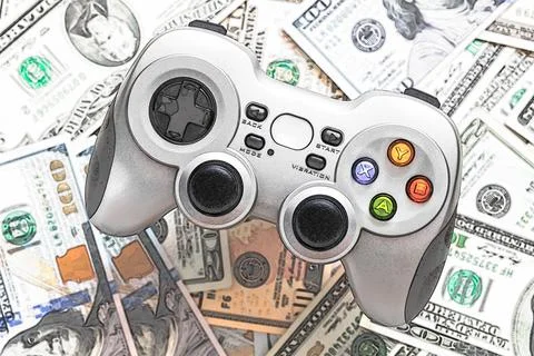 Silver wireless gamepad on dollar bills background Stock Photos