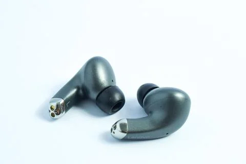 Silver wireless headset or earphone is called TWS Stock Photos