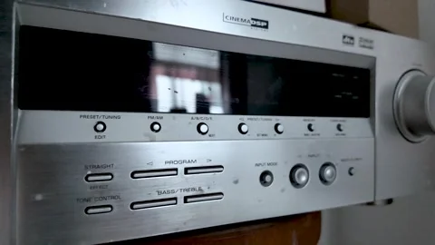 A silver Yamaha AV receiver is shown featuring Cinema DSP and multiple control Stock Footage 328345199