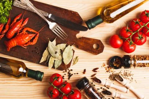 Silverware on the board with spices, cherry tomatoes and cancers 库存照片