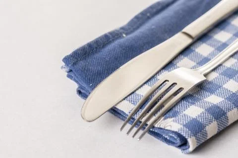 Silverware metal knife and fork on the blue kitchen dishtowel Stock Photos