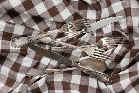 Silverware on a white and brown checked fabric Stock Photos