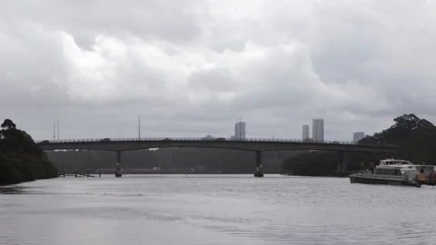 Silverwater Bridge with ferry passing through and birds close by on cloudy Stockbeeldmateriaal 274623232