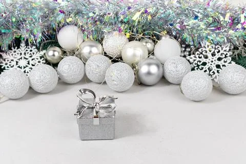 Silvery gift boxes on a blurred background with white and silver balls, garland Stock Photos